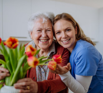 Caregiver hugging elderly